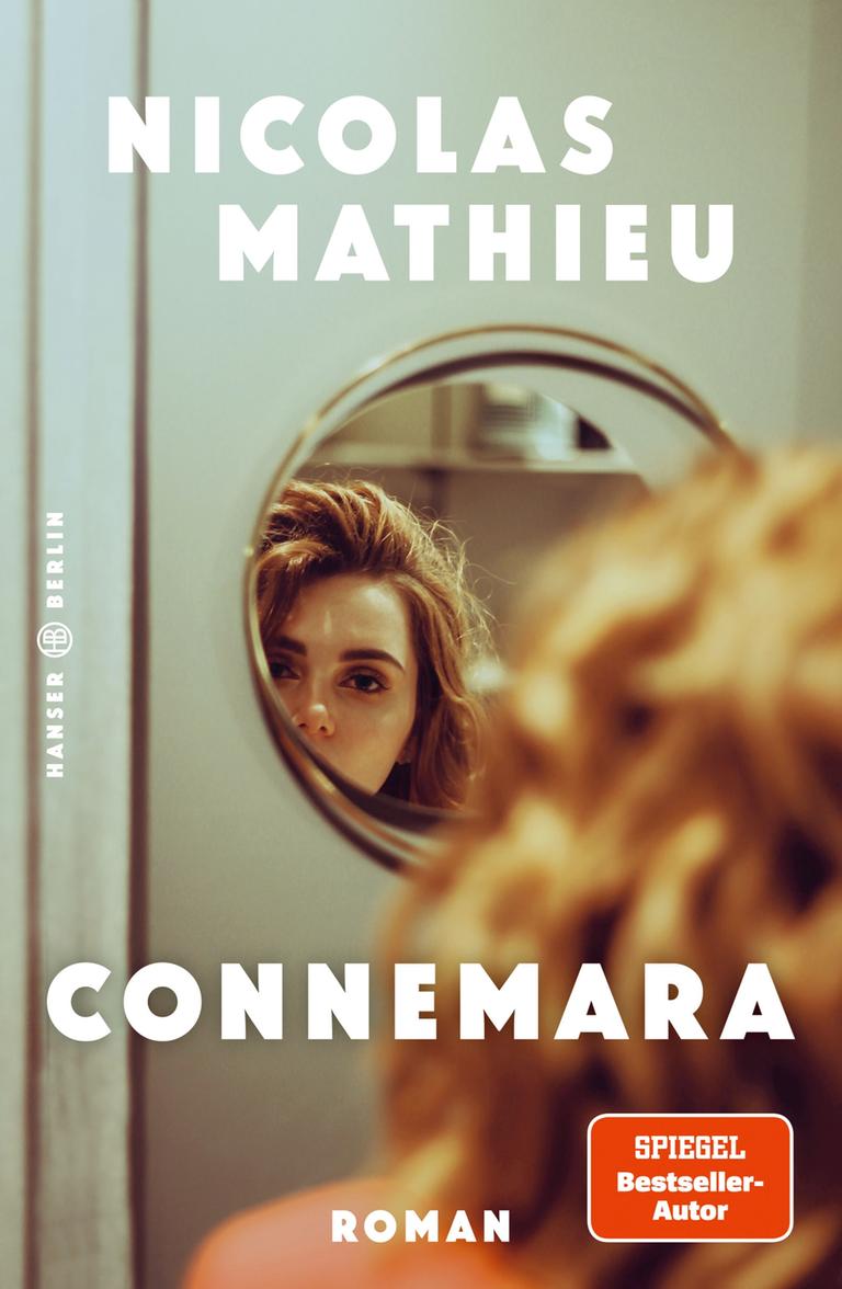 Das Cover des Buches "Connemara" von Nicolas Mathieu zeigt den Haarschopf einer Frau von hinten. Die Frau blickt in einen runden kleinen Spiegel. Das Cover des Buches "Connemara" von Nicolas Mathieu zeigt den Haarschopf einer Frau von hinten. Die Frau blickt in einen runden kleinen Spiegel.