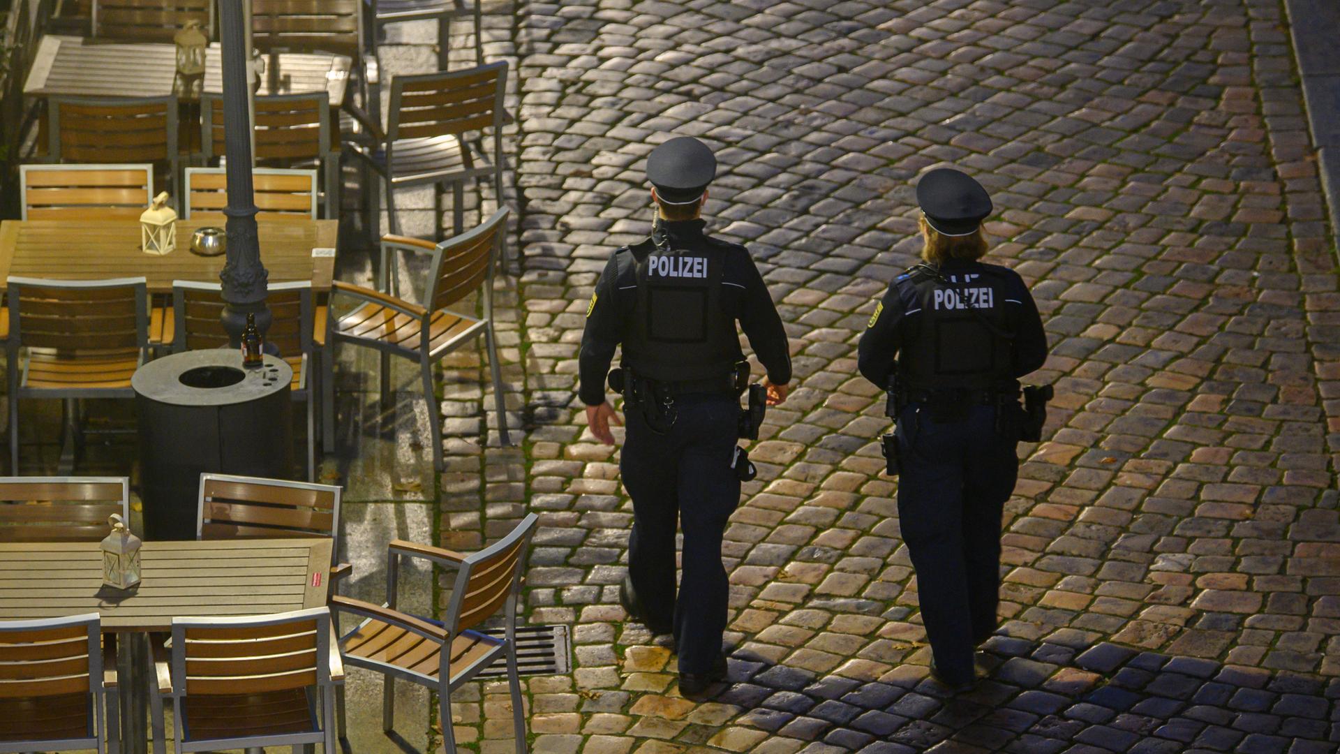 Polizisten laufen am Abend in der Dresdner Altstadt an Restaurants entlang. 