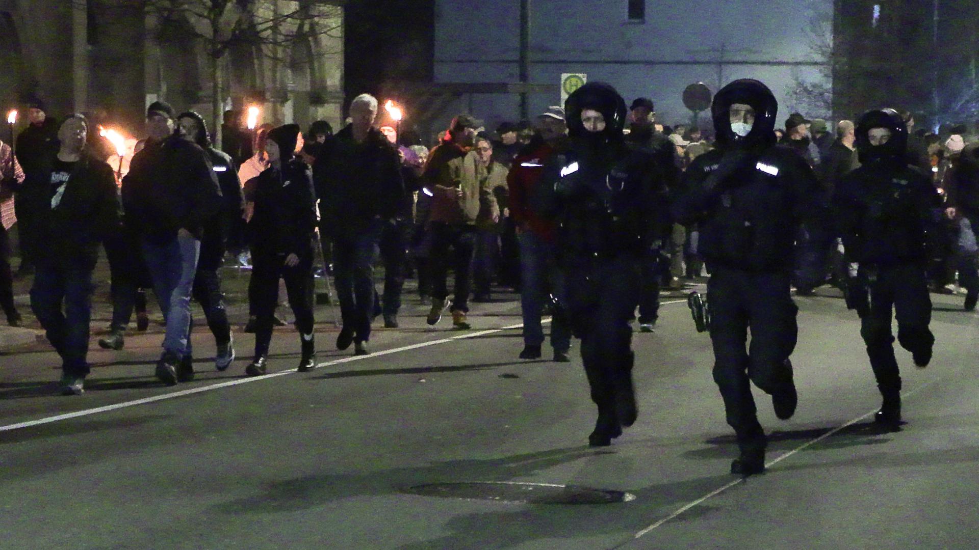 Das Foto zeigt Polizisten und Demonstrierende abends in Greiz in Thüringen.