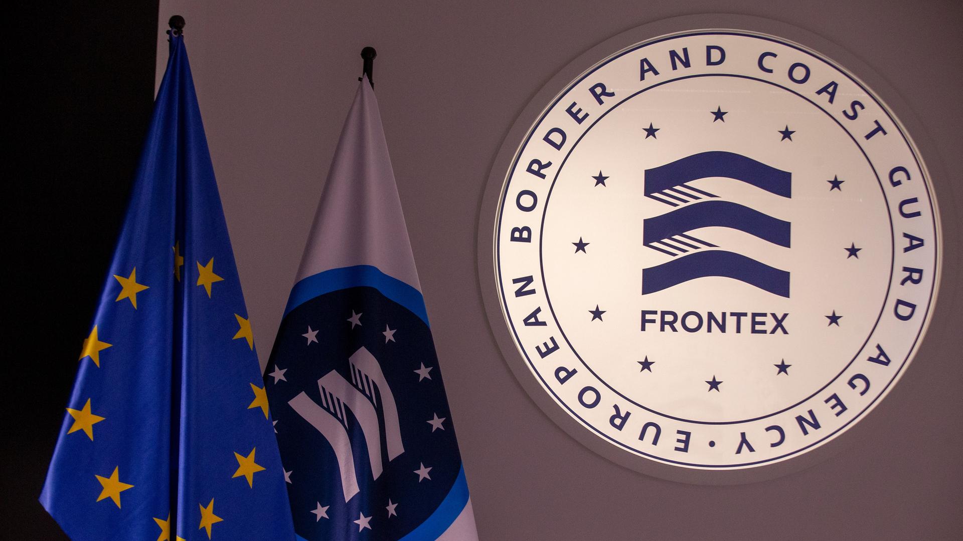 Das Frontex-Logo neben einer Frontex- und einer EU-Flagge