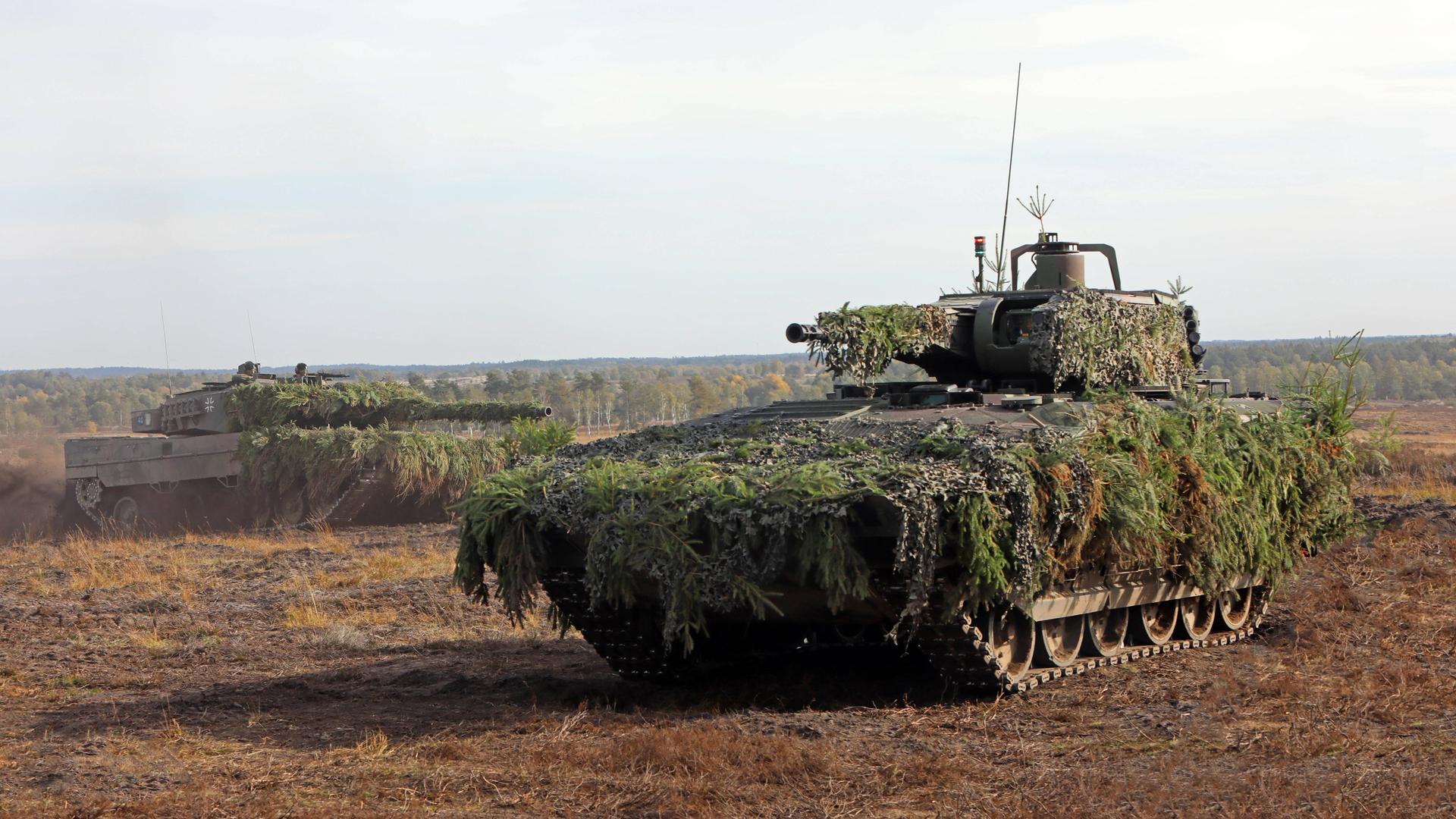 Ein getarnter Schützenpanzer Puma fährt auf einem Truppenübungsplatz bei einer Gefechtsvorführung