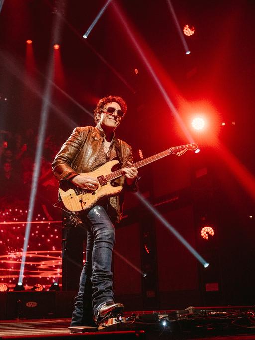 Journey-Konzert in Nashville. Der Gitarrist Neal Schon steht im roten Bühnenlicht. April 2022.