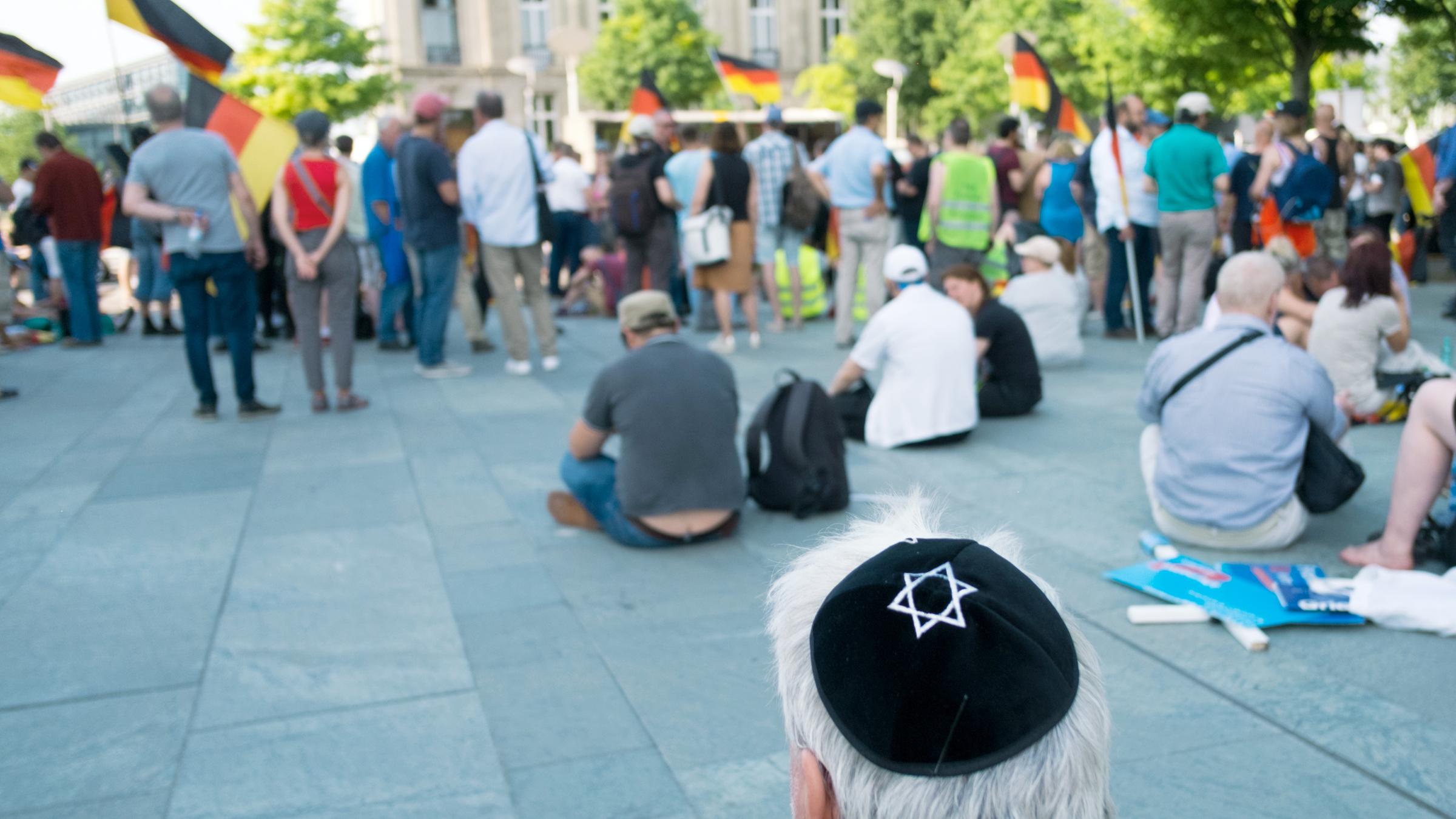 Ein Mann trägt während einer Kundgebung vor dem Bundeskanzleramt nach dem sogenannten "Frauenmarsch 2.0" eine Kippa mit Davidstern. Die Veranstaltung wurde von rechtspopulistischen Gruppierungen aus dem AfD-Umfeld organisiert.