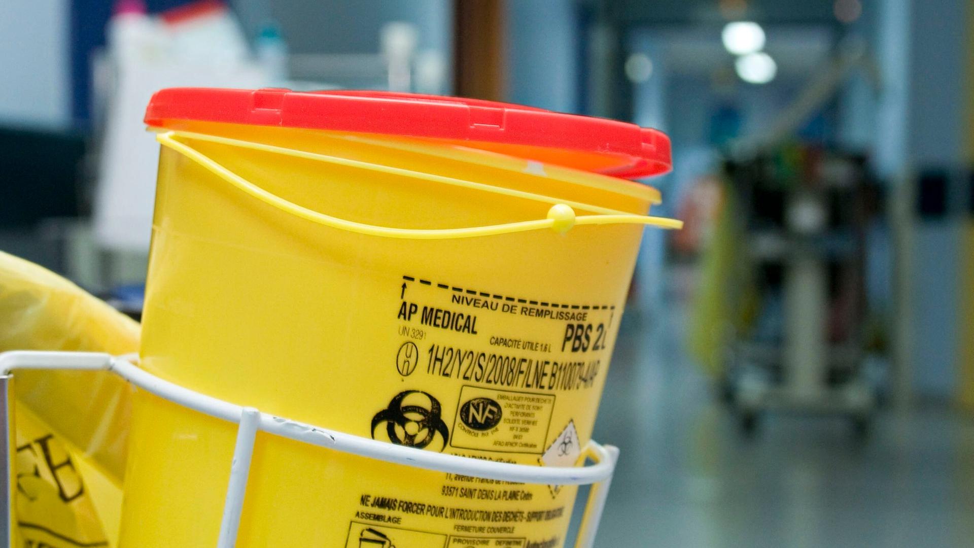 Müllbehälter mit Biohazard-Symbol in Krankenhausflur Müllbehälter mit Biohazard-Symbol in Krankenhausflur