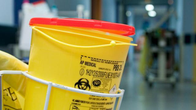 Müllbehälter mit Biohazard-Symbol in Krankenhausflur