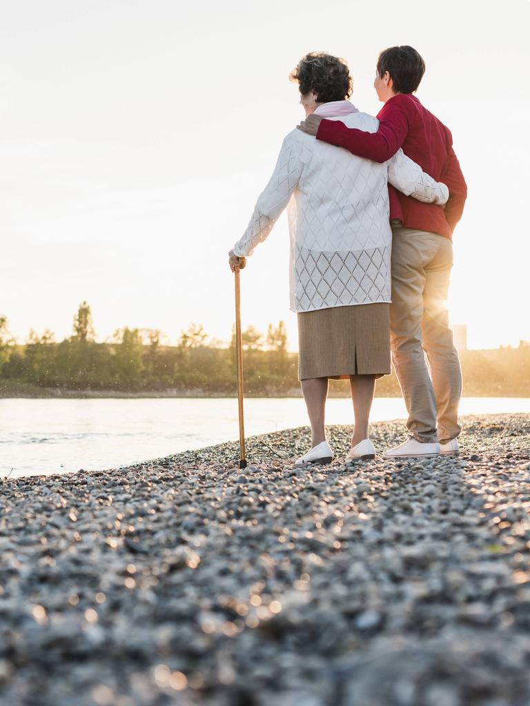 Eine alte und eine jüngere Frau stehen an am Strand und schauen aufs Wasser raus. Eine alte und eine jüngere Frau stehen an am Strand und schauen aufs Wasser raus.