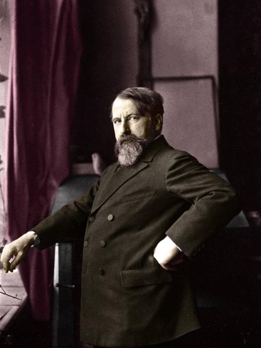 Porträt von 1900: Arthur Schnitzler im Anzug, in selbstbewusster Pose mit der Hand in die Hüfte gestemmt.