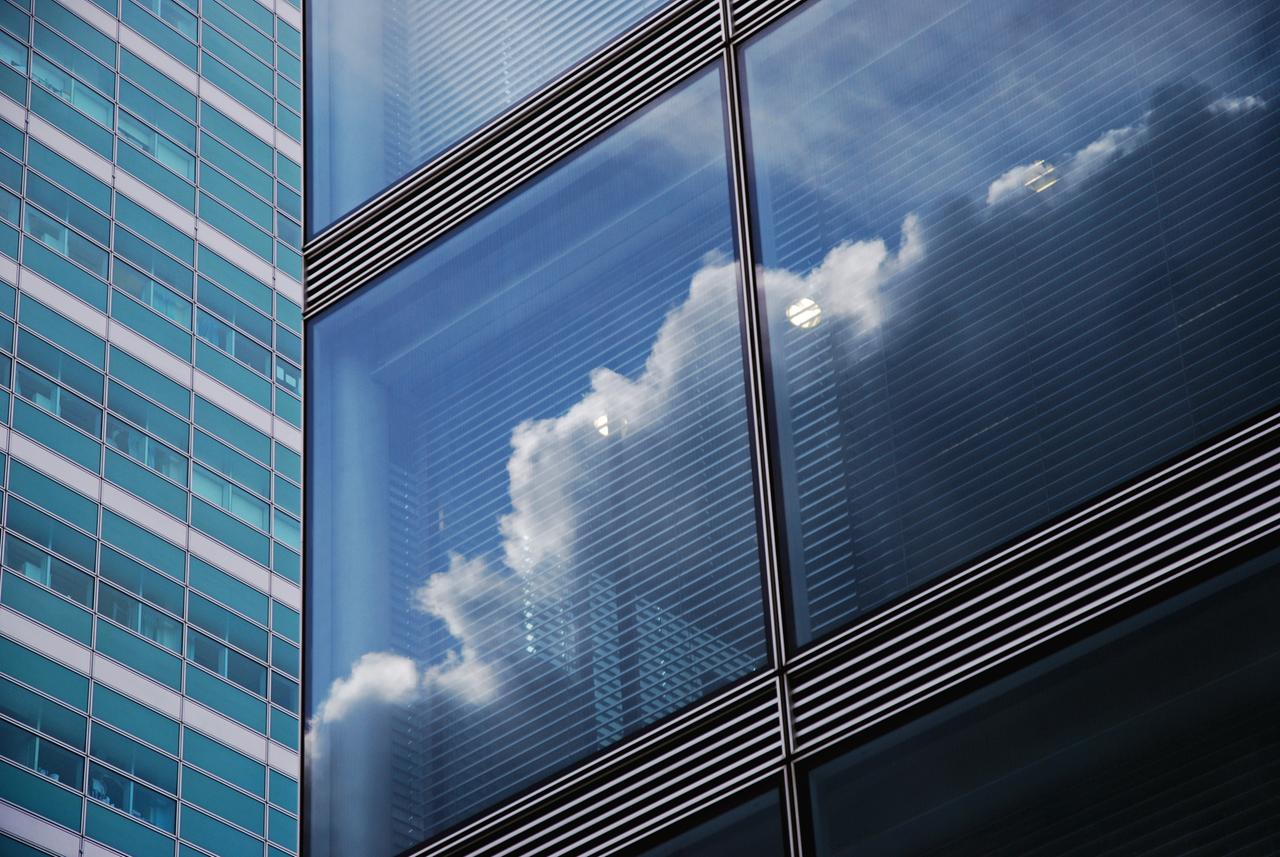 Wolken spiegeln sich im Fenster eines Klinikgebäudes. Wolken spiegeln sich im Fenster eines Klinikgebäudes.