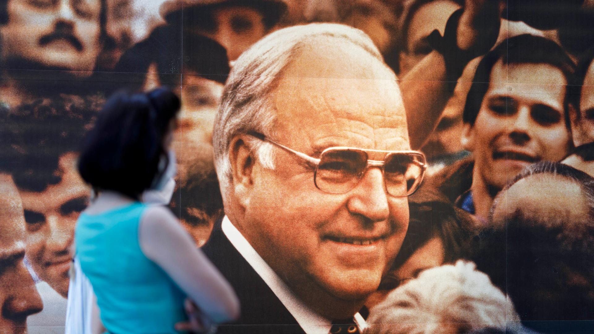 Eine Frau vor einem Wahlplakat mit Helmut Kohl in der Ausstellung "Wähl mich! Parteien plakatieren", die 2021 im Haus der Geschichte in Bonn zu sehen war.