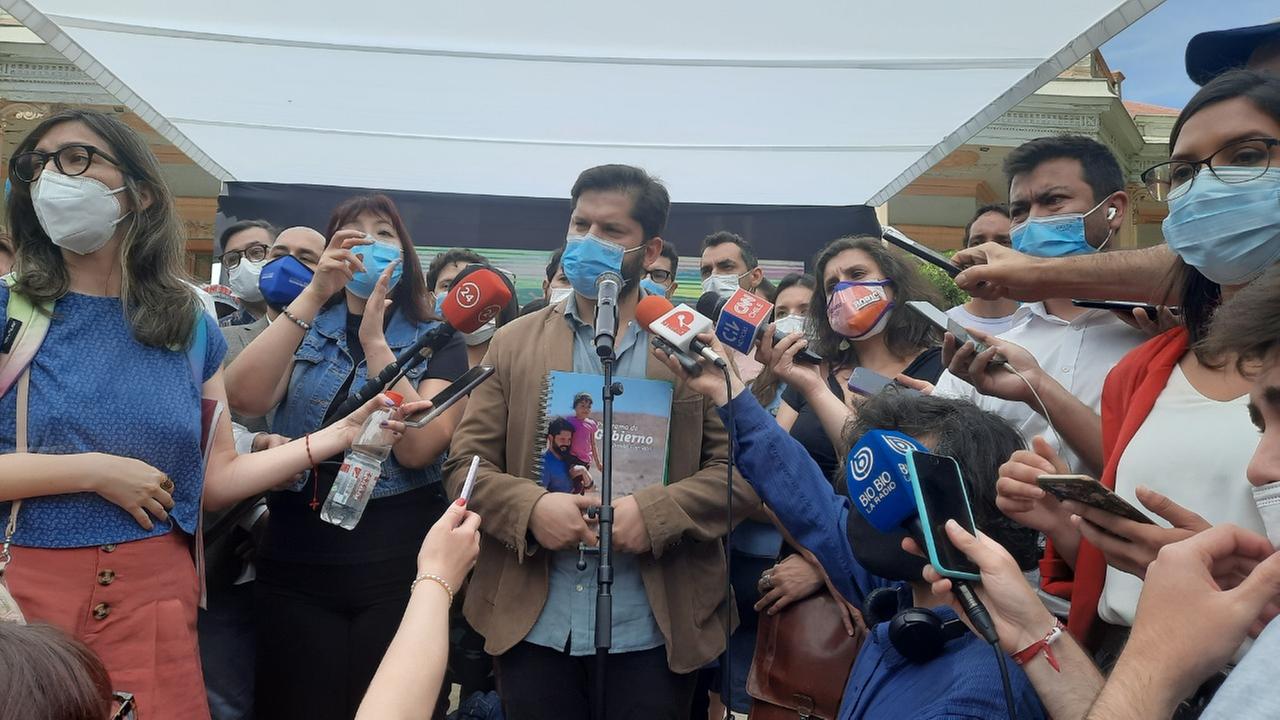 Ein junger Mann mit Vollbart und Mundschutz wird umringt von Journalisten, die ihm ihre Mikrofone entgegenstrecken. Ein junger Mann mit Vollbart und Mundschutz wird umringt von Journalisten, die ihm ihre Mikrofone entgegenstrecken.