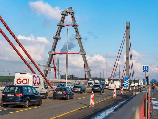 Verkehr auf der alten Brücke der A1 über den Rhein bei Leverkusen, daneben der Bau der neuen Brücke.
