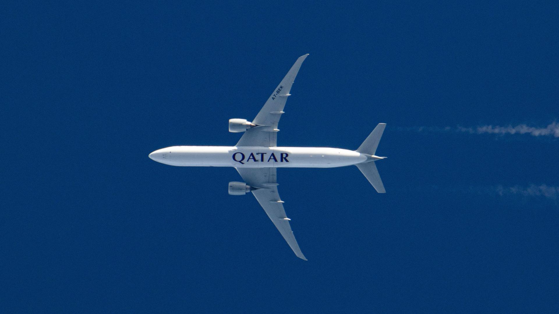 Rumpf einer fliegenden Qatar Airways Boeing 777 vom Boden aus gesehen Rumpf einer fliegenden Qatar Airways Boeing 777 vom Boden aus gesehen