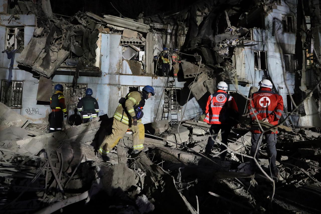 Feuerwehrleute des ukrainischen Katastrophenschutzes inspizieren ein beschädigtes Haus nach einem russischen Raketenanschlag. 