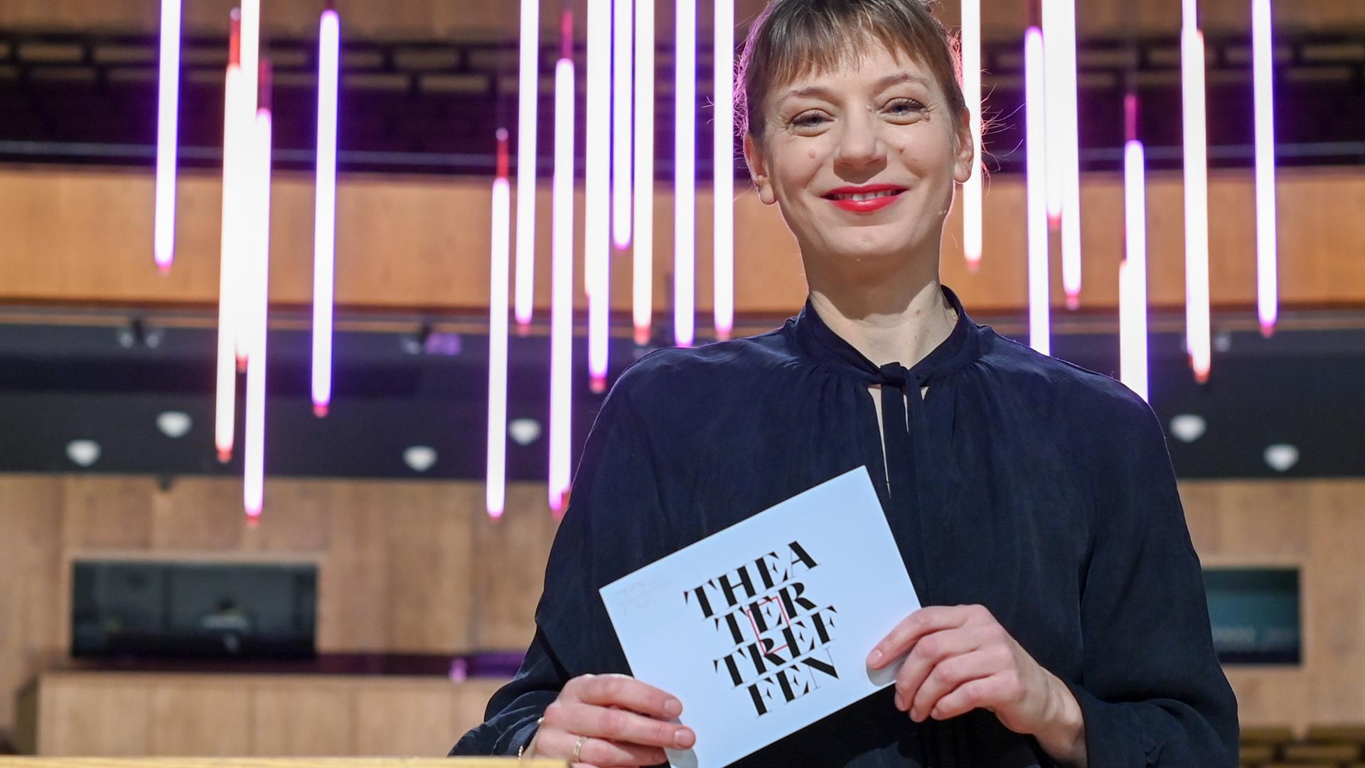 Yvonne Büdenhölzer, Leiterin des Theatertreffens der Berliner Festspiele, hält eine Karte mit der Aufschrift "Theatertreffen" in der Hand. Yvonne Büdenhölzer, Leiterin des Theatertreffens der Berliner Festspiele, hält eine Karte mit der Aufschrift "Theatertreffen" in der Hand.