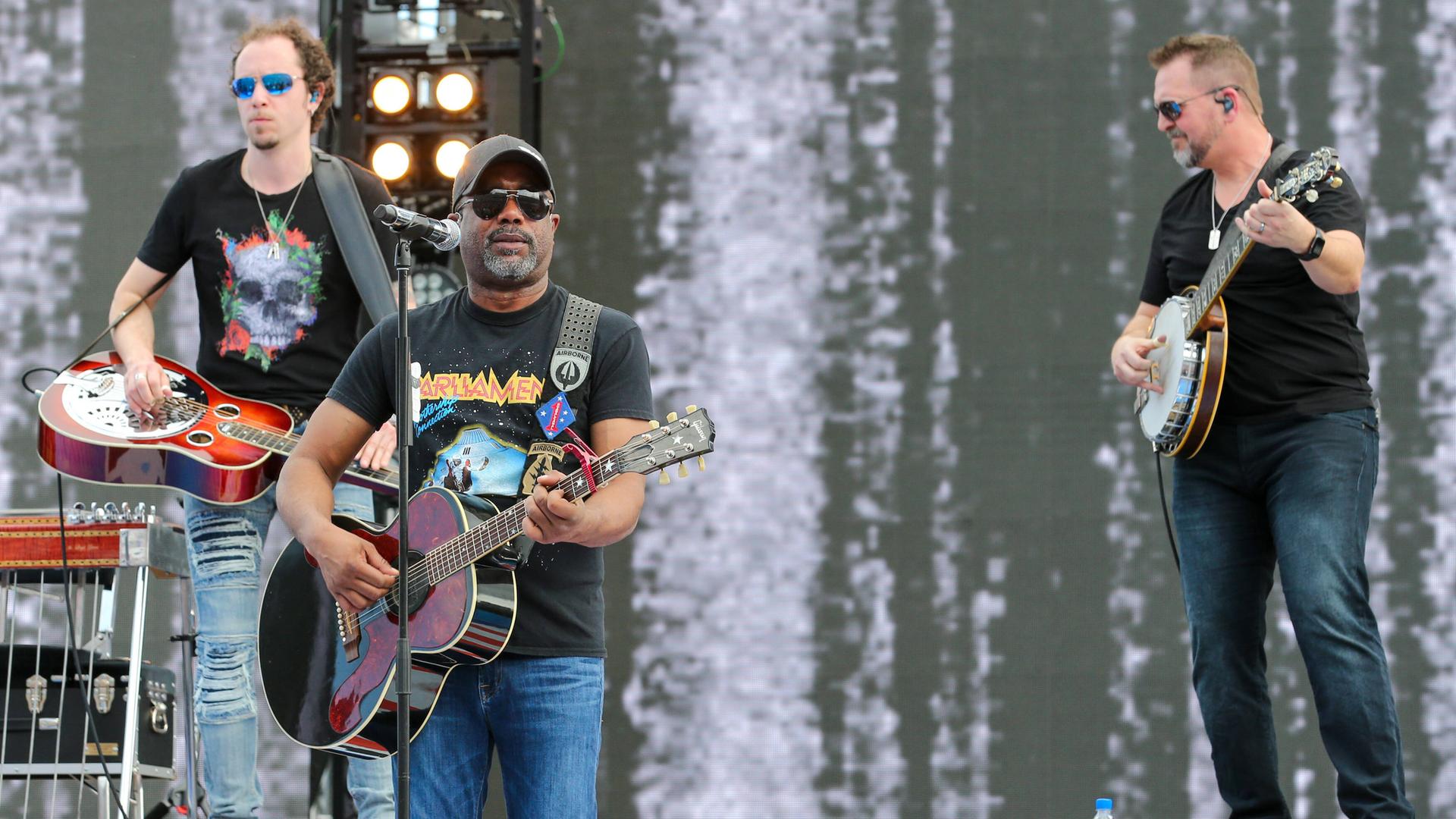 Der Country-Musiker Darius Rucker steht mit Gitarre auf einer Bühne