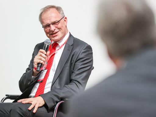 Stefan Raue, Intendant des Deutschlandradio, hier 2021 auf einem Podium der Medientage Mitteldeutschland mit Mikrofon in der Hand