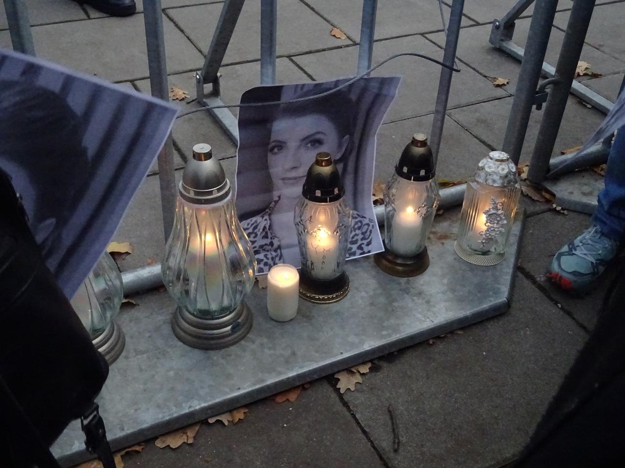 Auf dem Boden steht ein Foto der verstorbenen Frau, davor Kerzen.