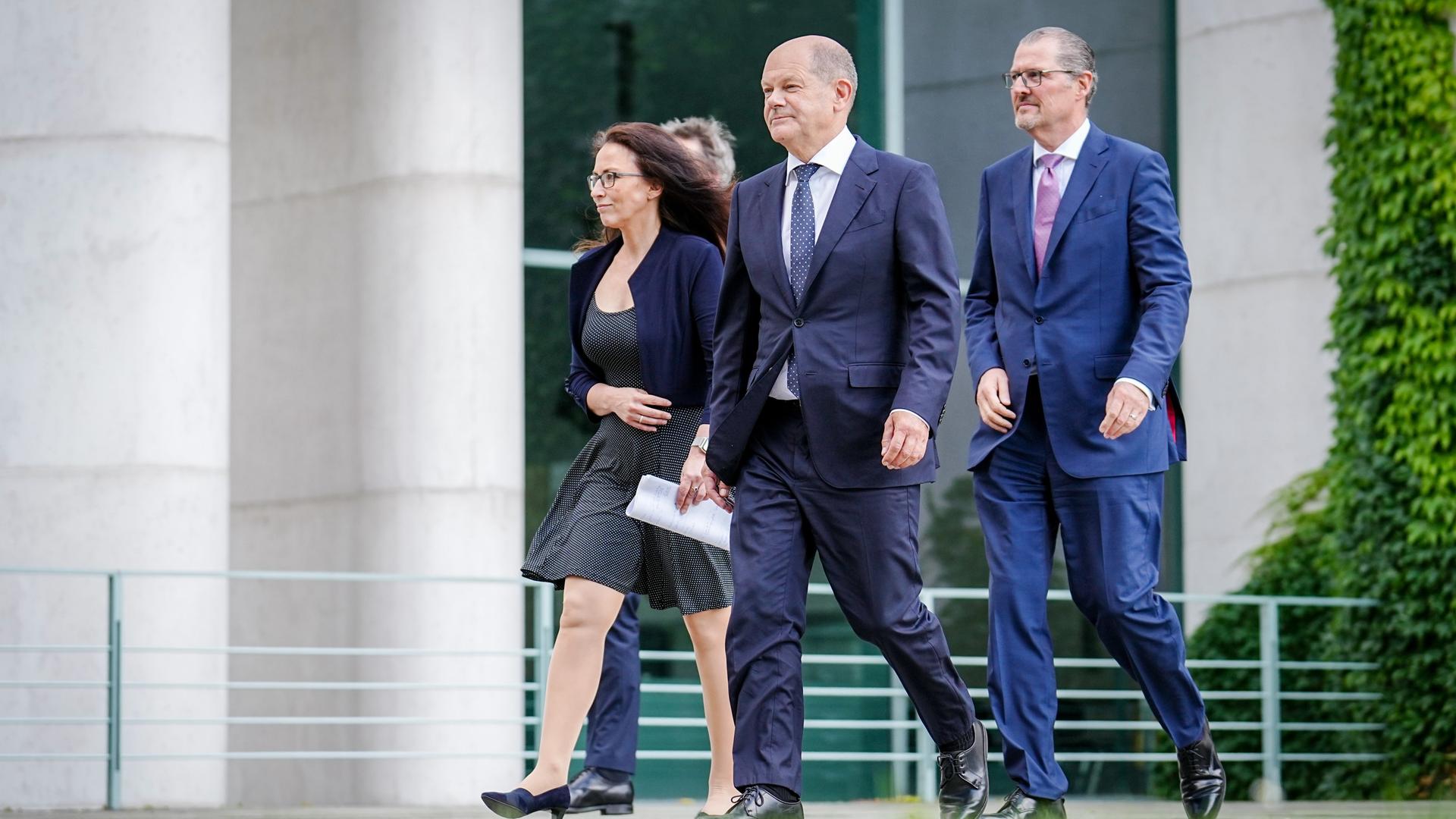 Bundeskanzler Olaf Scholz (M, SPD), Yasmin Fahimi, DGB-Chefin, und Rainer Dulger, Arbeitgeberpräsident, laufen gemeinsam durch die Anlage des Kanzleramtes.