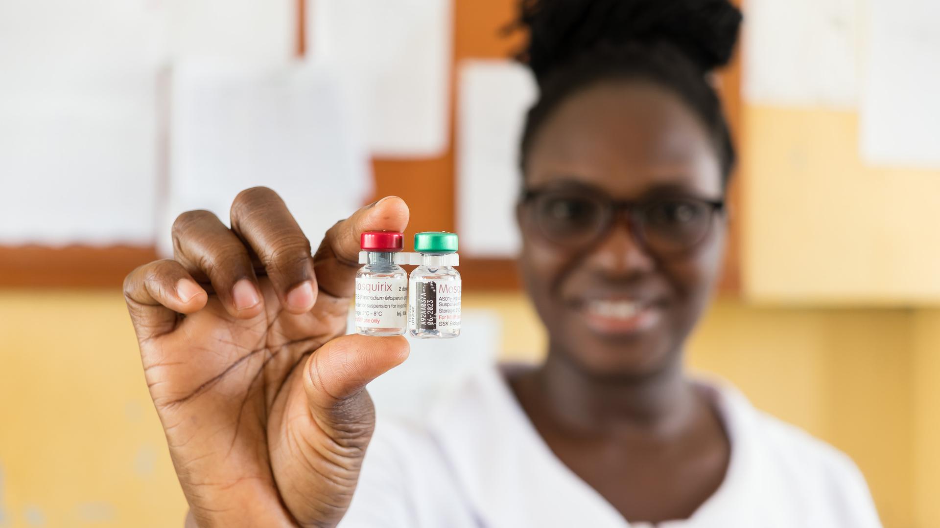 Eine Mitarbeiterin der Poliklinik in Capecoast hält zwei Döschen mit dem Impfstoff Mosquirix in die Kamera Eine Mitarbeiterin der Poliklinik in Capecoast hält zwei Döschen mit dem Impfstoff Mosquirix in die Kamera