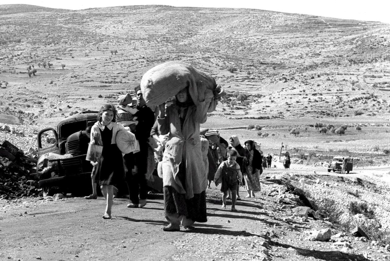 Palästinensische Frauen und Kinder tragen ihr Hab und Gut mit sich. Während des ersten arabisch-israelischen Krieges 1948/49 flohen Tausende Menschen unter anderem in Richtung Libanon. 