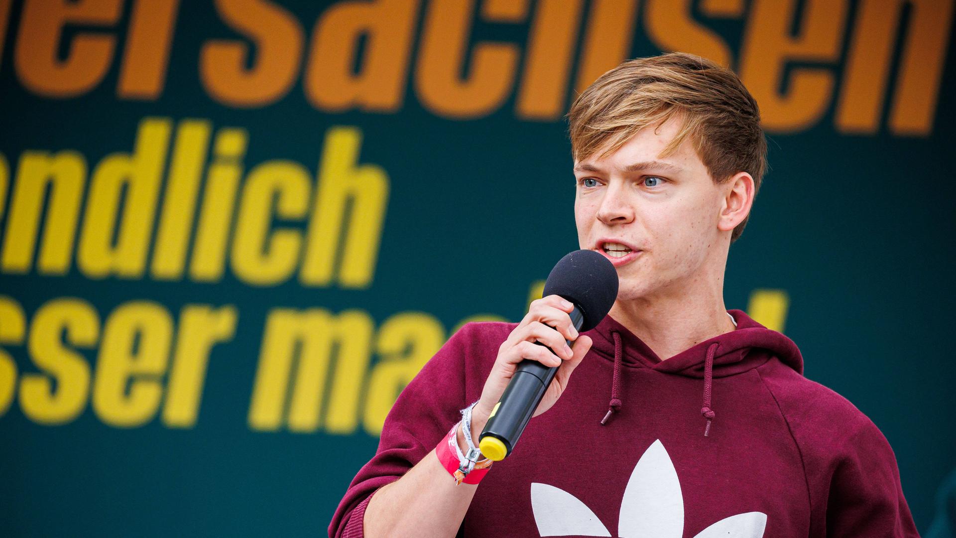 Timon Dzienus, Bundessprecher der Grünen Jugend, redet auf einer Bühne während einer Wahlkampfveranstaltung der Grünen zur Landtagswahl Niedersachsen