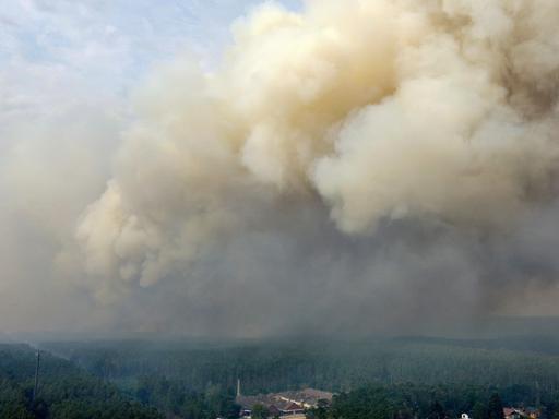 Eine große Rauchwolke steigt wegen eines Waldbrandes in der Nähe von Beelitz, Brandenburg, auf.