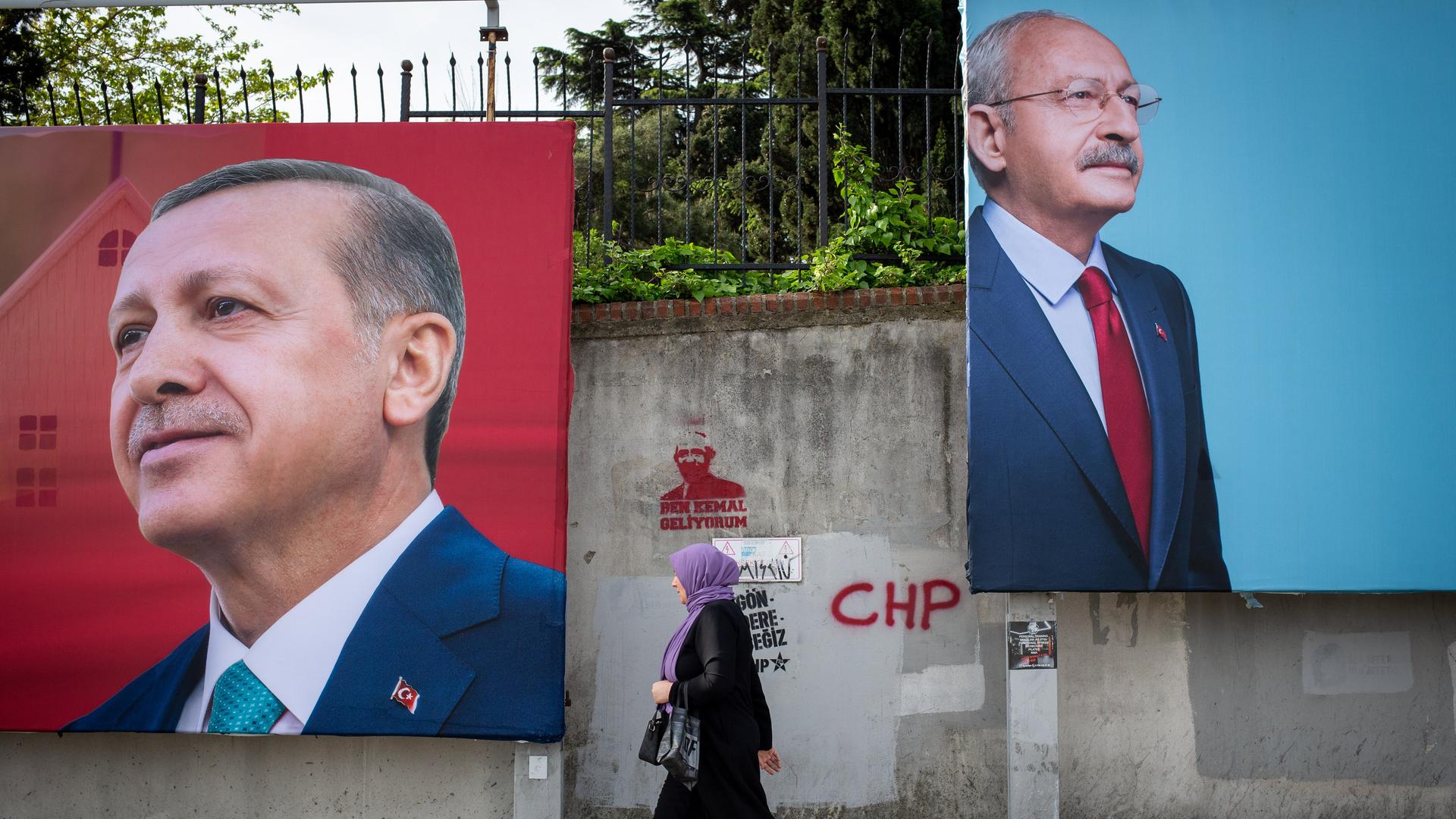 An einer Straße in Istanbul hängen große Werbeplakate von Langzeitpräsident Erdogan und Herausforderte Kemal Kilicdaroglu. Eine Frau geht an den Plakaten entlang. 