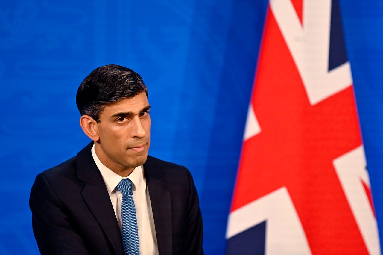 Britischer Finanzminister Rishi Sunak, neben ihm hängt die britische Flagge. 