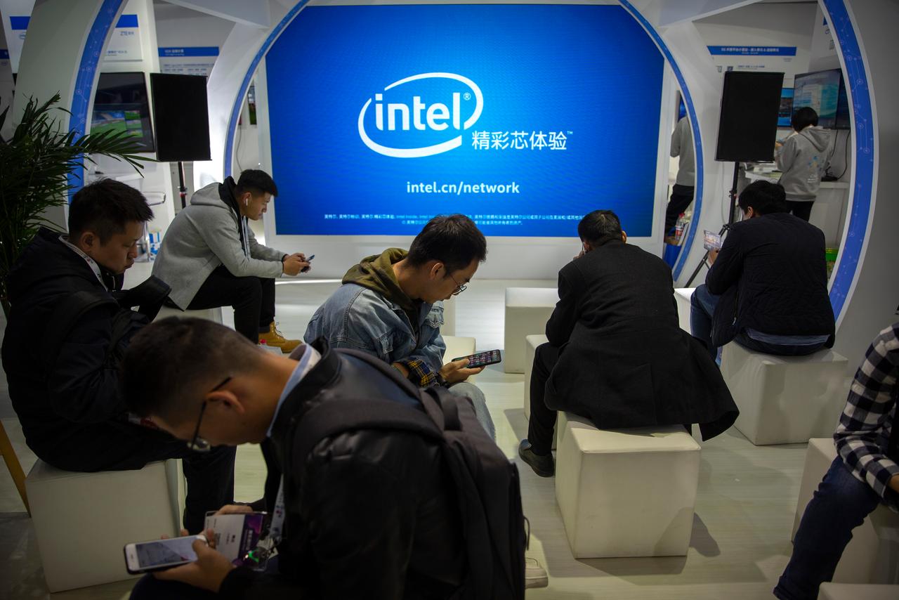 Menschen sitzen vor einem Intel-Stand bei einer Messe in China. Menschen sitzen vor einem Intel-Stand bei einer Messe in China.