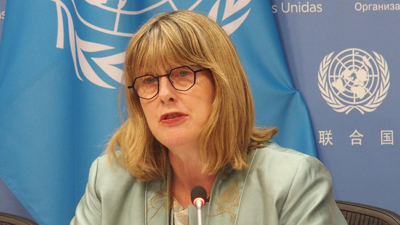 UN-Experte Ni Aolain spricht auf einer Pressekonferenz. Hinter ihr sind blaue Banner mit dem Logo der Vereinten Nationen zu sehen.