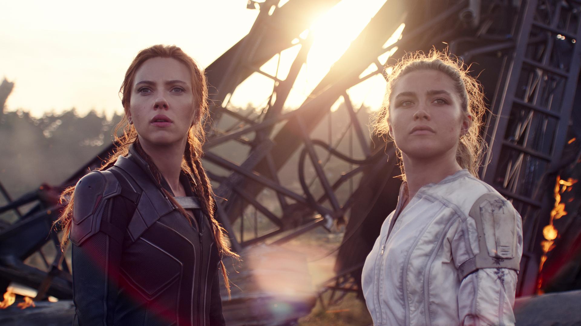 Scarlett Johansson (li.) und Florence Pugh im Marvel-Film Black Widow vor zerborstener Kulisse. Scarlett Johansson (li.) und Florence Pugh im Marvel-Film Black Widow vor zerborstener Kulisse.