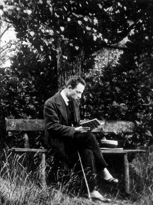 Der Schriftsteller Rainer Maria Rilke lesend auf einer Parkbank in Rippoldsau im Schwarzwald, ca. 1913.