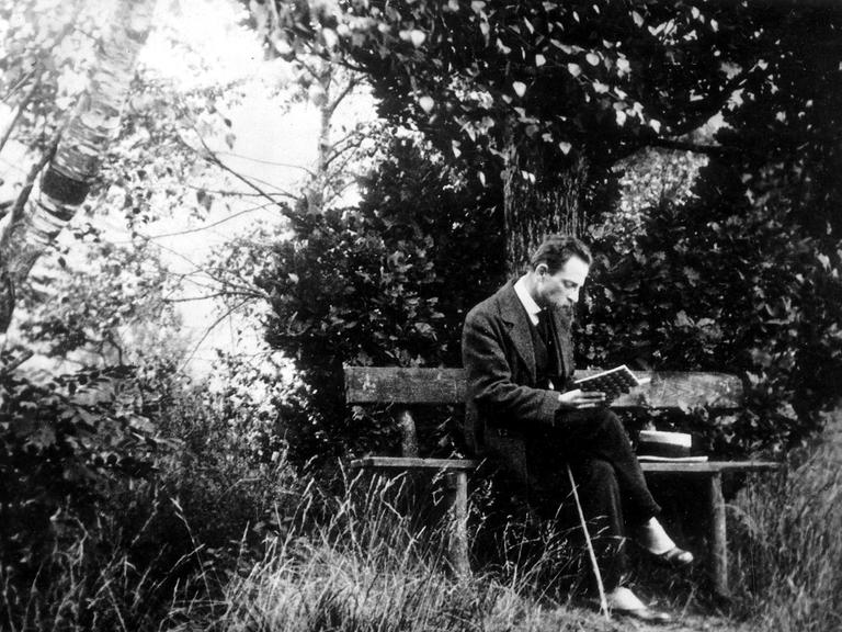 Der Schriftsteller Rainer Maria Rilke lesend auf einer Parkbank in Rippoldsau im Schwarzwald, ca. 1913.