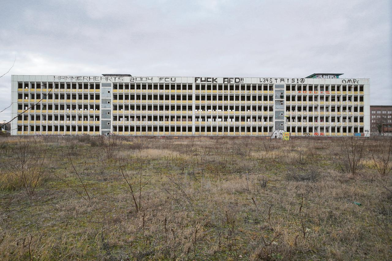 Das Foto aus dem Buch Vanishing Berlin von Alexander Steffen zeigt eine Brache mit einem leer stehenenden Gebäude aus DDR-Zeiten.