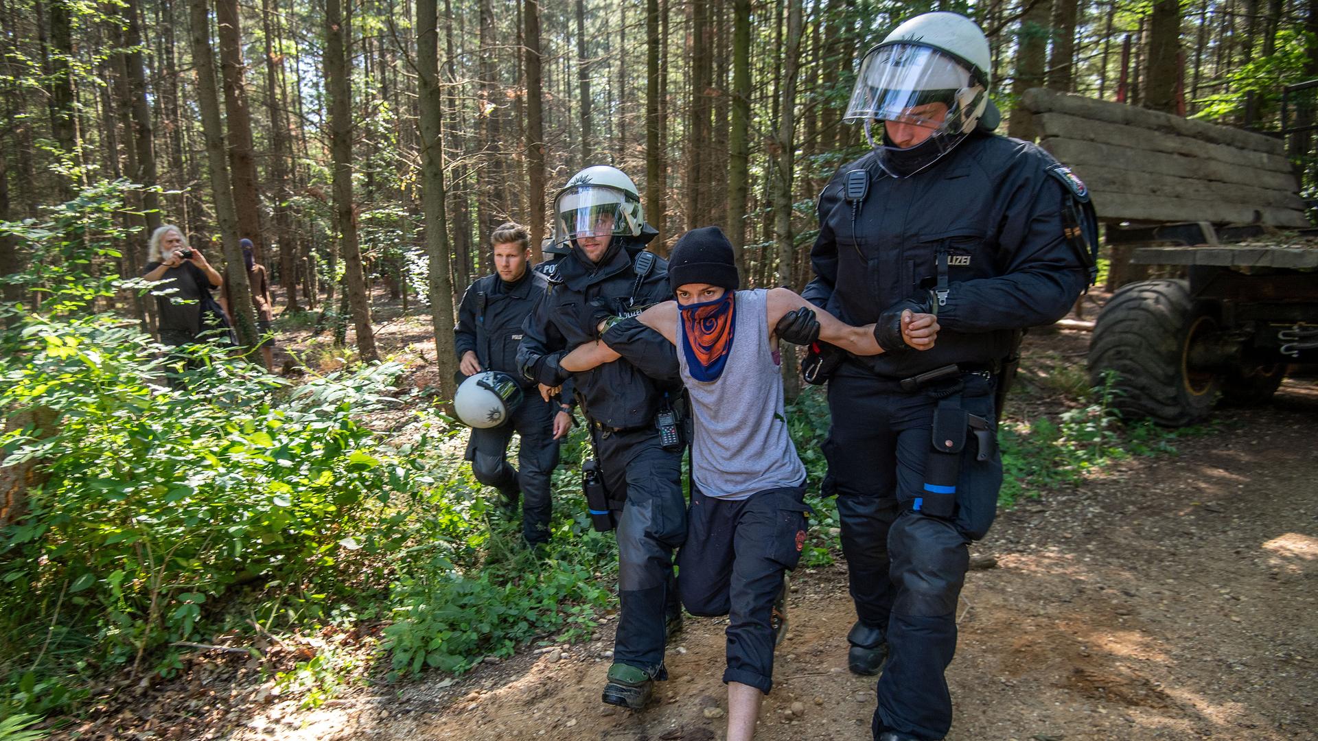Polizisten führen im Sommer 2020 im Hambacher Wald eine Umweltaktivistin ab. Polizisten führen im Sommer 2020 im Hambacher Wald eine Umweltaktivistin ab.