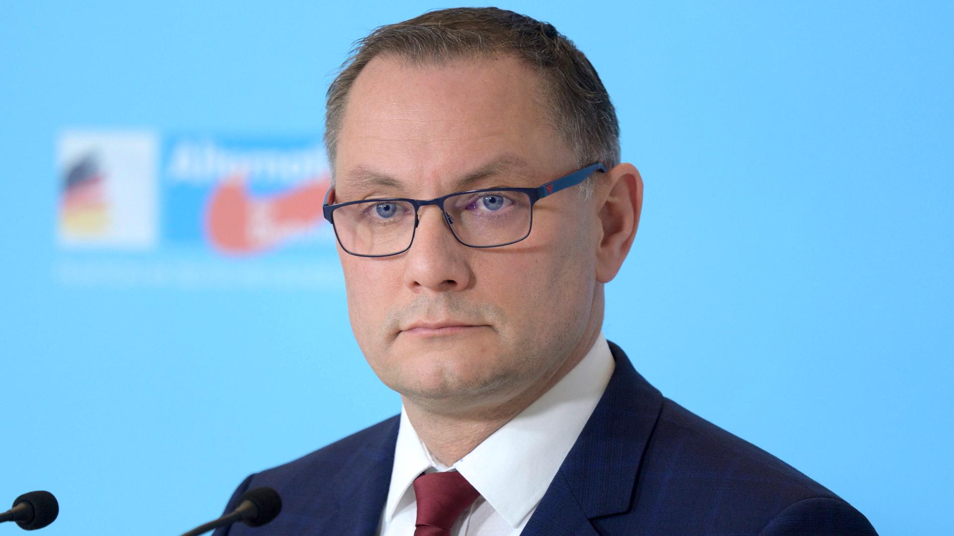 Tino Chrupalla , Co-Vorsitzender der AfD-Fraktion im Bundestag , im Porträt vor einer hellblauen Wand mit AfD-Logo Tino Chrupalla , Co-Vorsitzender der AfD-Fraktion im Bundestag , im Porträt vor einer hellblauen Wand mit AfD-Logo