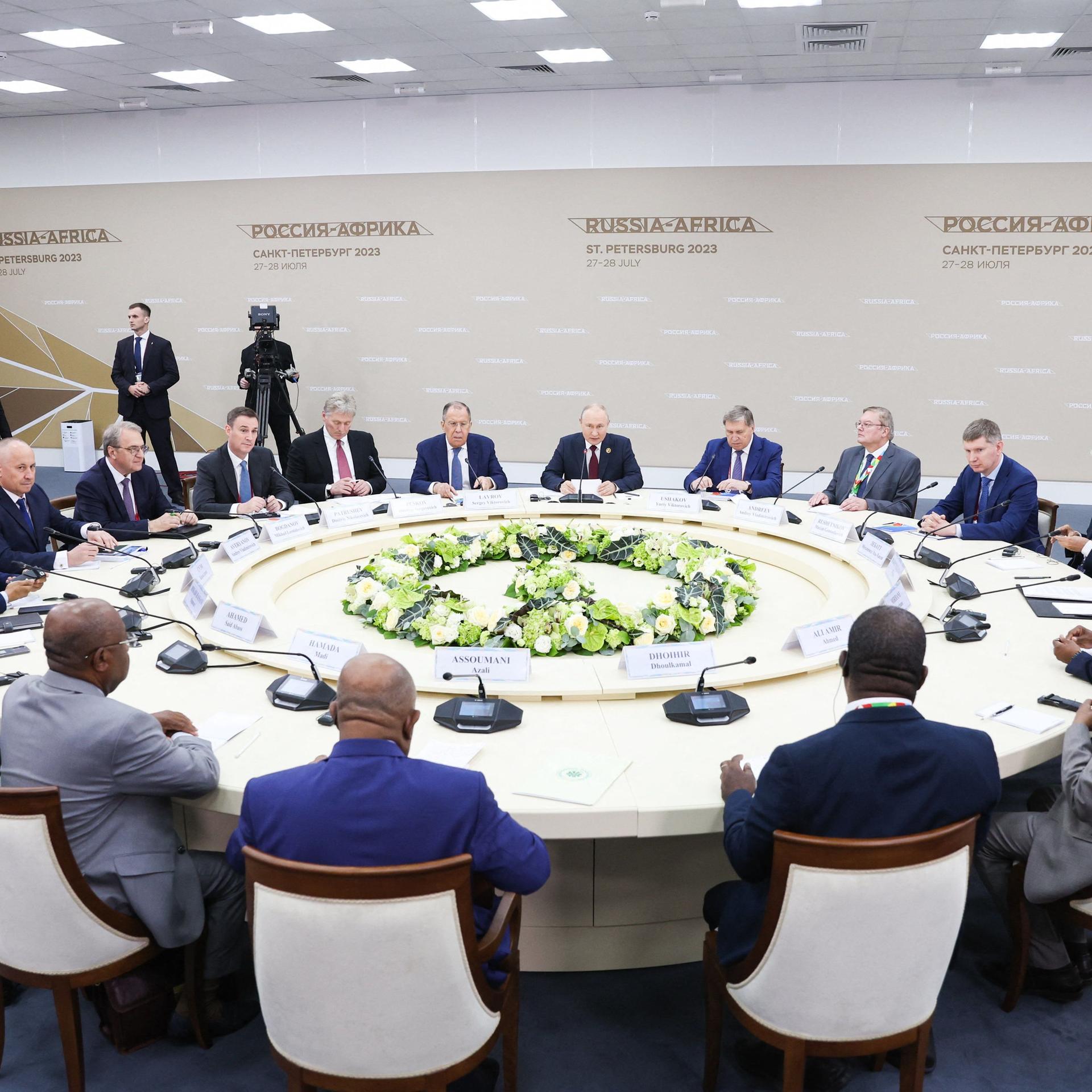 Präsident Putin sitzt mit Teilnehmern des Russland-Afrika-Gipfels an einem runden Tisch.