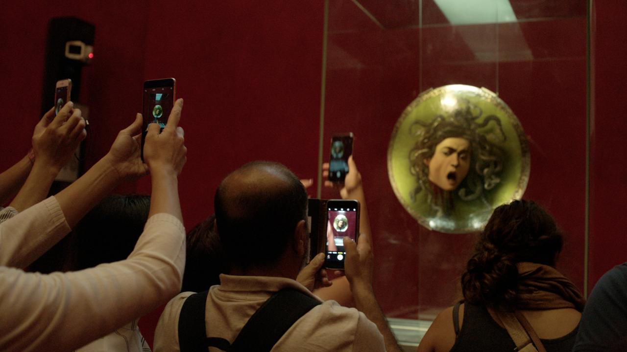 Besucher mit gezückten Smartphones fotografieren ein Gemäde der Medusa.