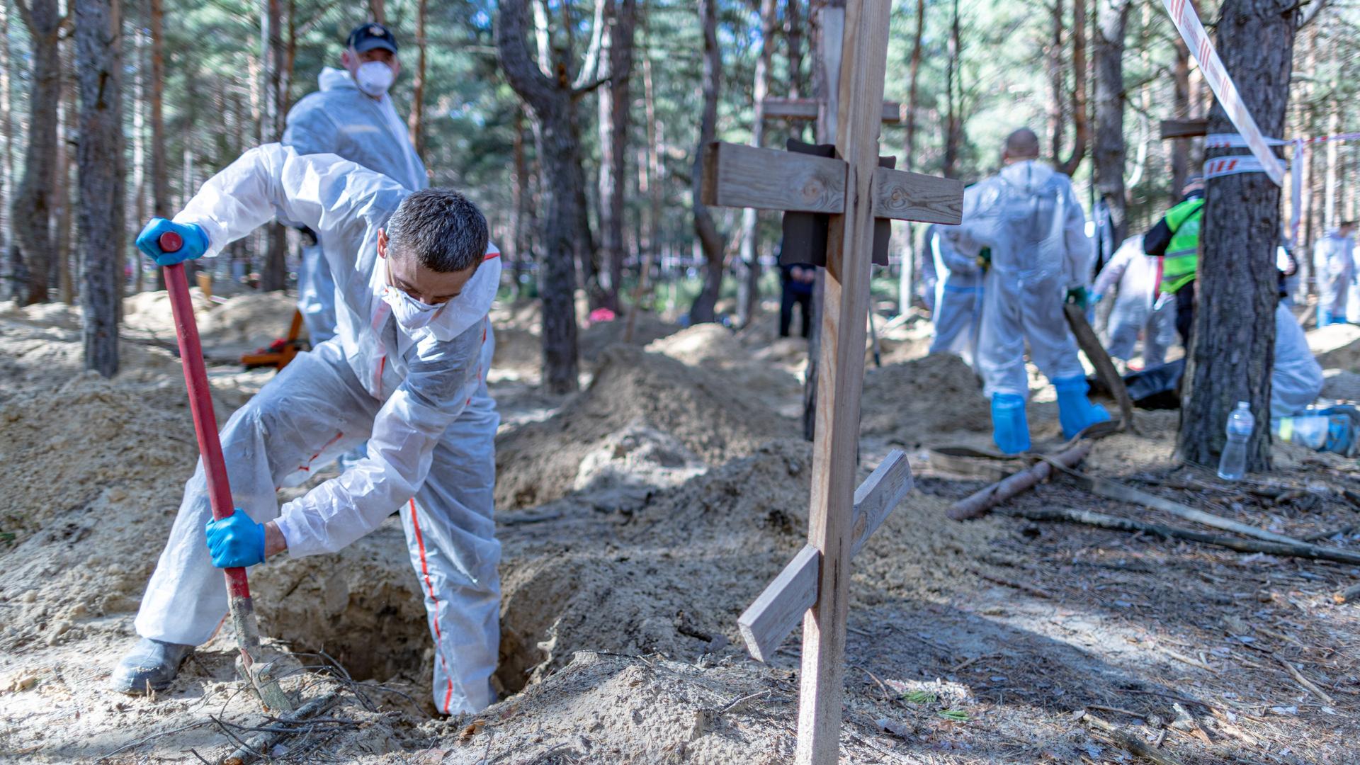 Ukrainische Forensiker beim Ausheben eines Grabs in der Nähe von Isjum in der Ostukraine. Ukrainische Forensiker beim Ausheben eines Grabs in der Nähe von Isjum in der Ostukraine.