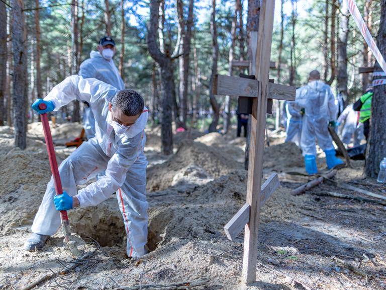 Ukrainische Forensiker beim Ausheben eines Grabs in der Nähe von Isjum in der Ostukraine.