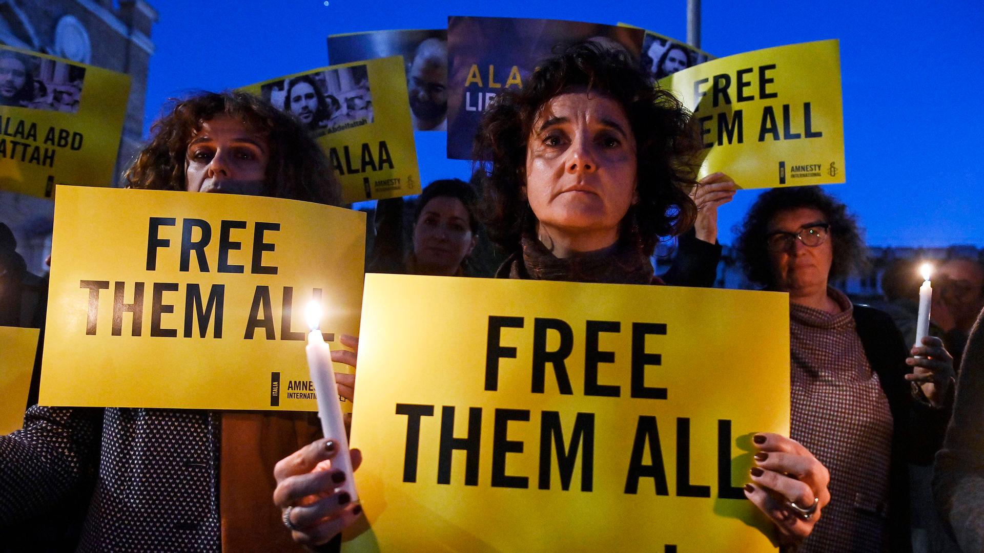 Demonstration für ägyptische Aktivisten: Menschen stehen auf einem Platz in Rom mit Zetteln in der Hand, auf denen steht „Free them all“ – „Lasst sie alle frei“. Demonstration für ägyptische Aktivisten: Menschen stehen auf einem Platz in Rom mit Zetteln in der Hand, auf denen steht „Free them all“ – „Lasst sie alle frei“.