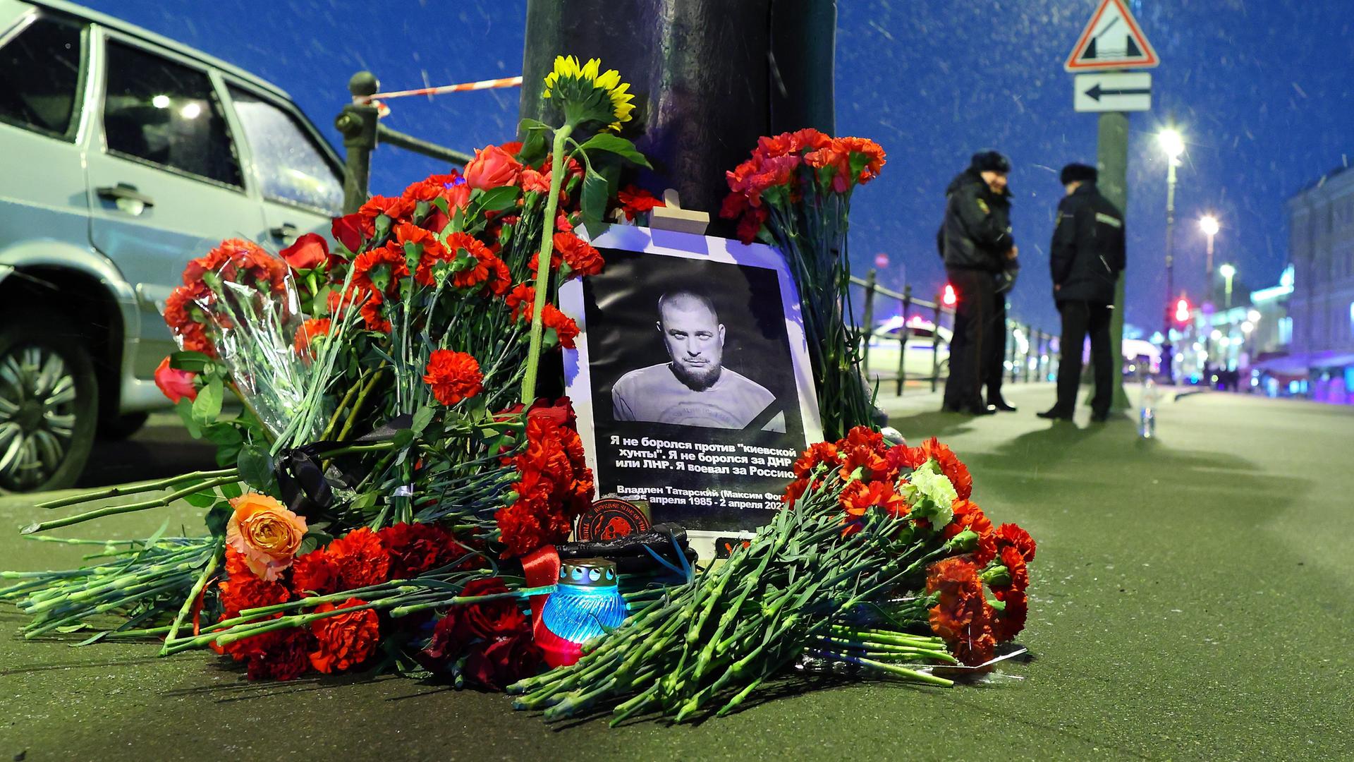Blumen, Kerzen und ein Bild des Bloggers Tatarskij liegen vor dem Café in St. Petersburg, in dem der Mann umkam
