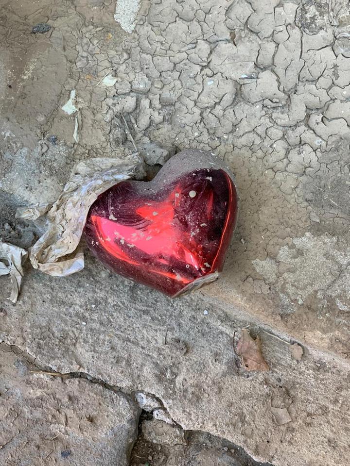 Ein rot glänzendes Dekoherz liegt im Dreck. Ein rot glänzendes Dekoherz liegt im Dreck.