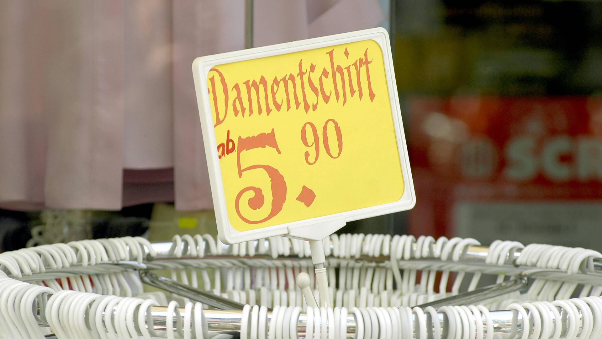 Damentschirt - Preisschild auf einer Kleiderstange. Damentschirt - Preisschild auf einer Kleiderstange.