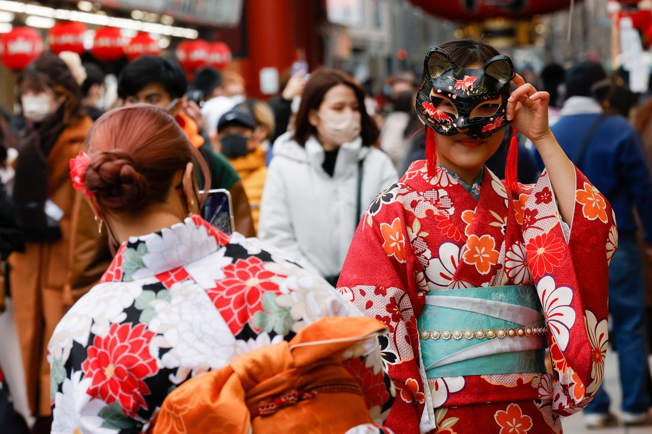Zwei Frauen im roten Kimono inmitten eines Einkaufzentrums in Tokio. 