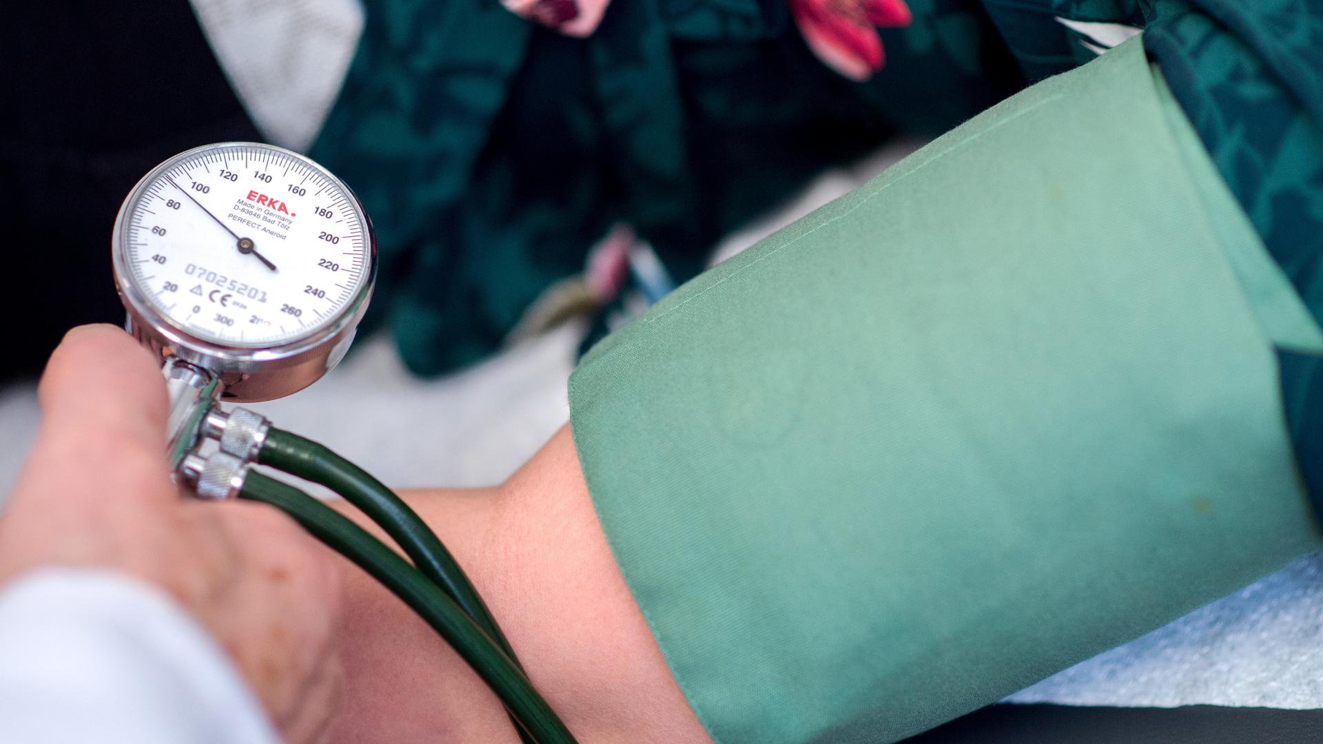 Ein Arzt misst den Blutdruck einer Patientin Ein Arzt misst den Blutdruck einer Patientin