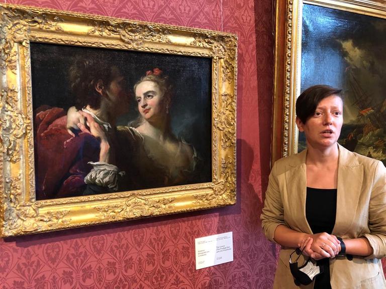 Kateryna Tschujewa steht im Chanenko-Museum vor einem restituierten Gemälde. Kateryna Tschujewa steht im Chanenko-Museum vor einem restituierten Gemälde.