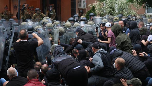 Das Foto zeigt Serben, die protestieren und Polizisten und Soldaten.