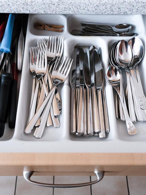 Besteckkasten mit Küchenutensilien wie Messer, Gabel, Löffel, Gemüsemesser in einer Einbauküche