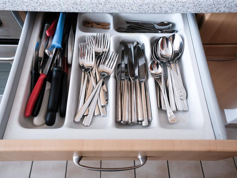 Besteckkasten mit Küchenutensilien wie Messer, Gabel, Löffel, Gemüsemesser in einer Einbauküche